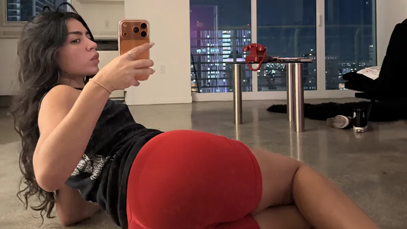 Zoe in red shorts with her phone